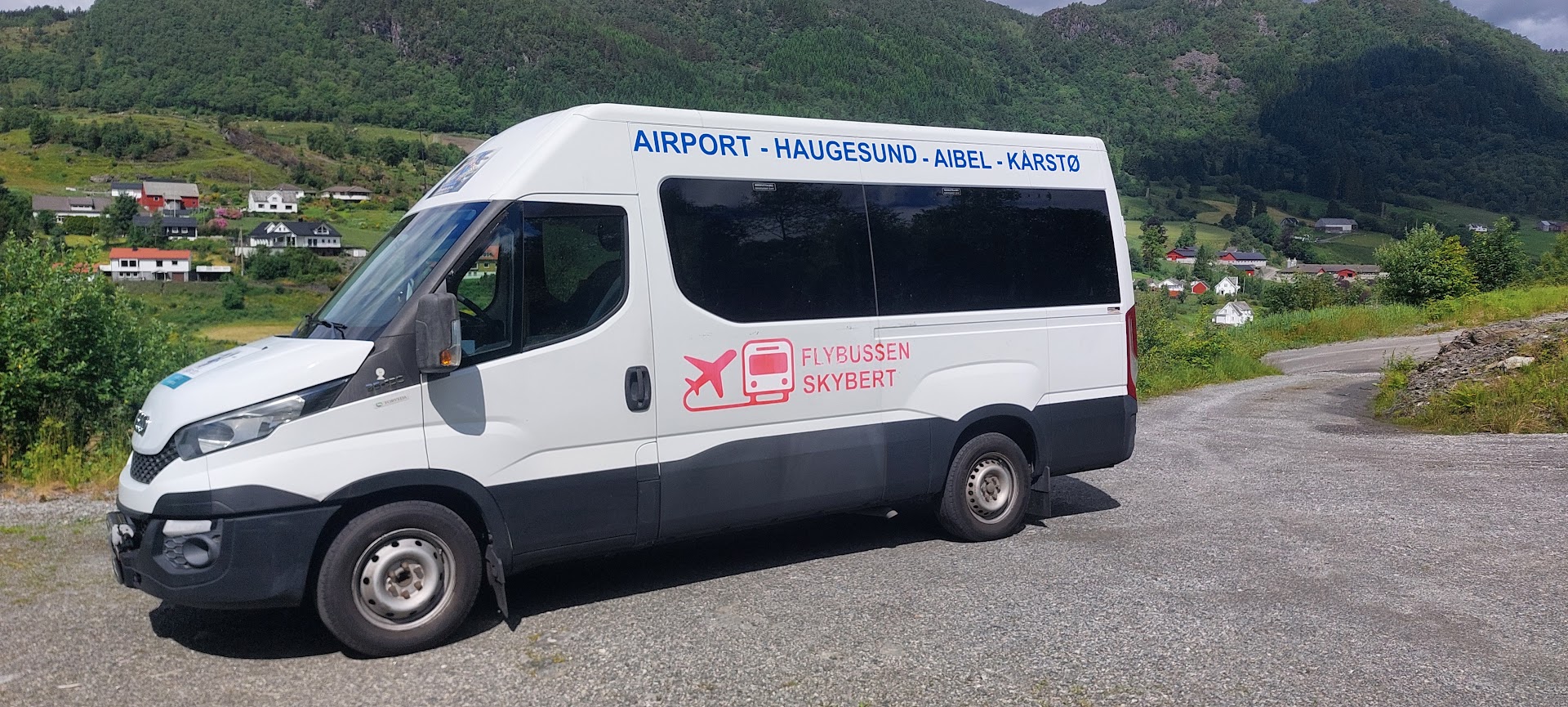 Hvit Iveco minibuss med Skybert-profilering, fotografert utendørs